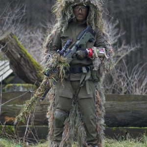 A Person in Green and Brown Camouflage Jacket Holding a Machine Gun
