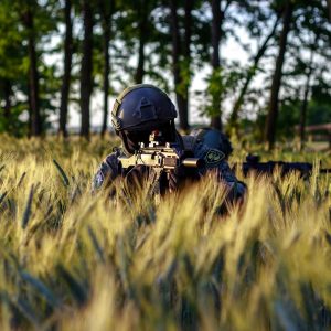 An Airsoft Player in Tactical Gear on a Wheat Field