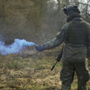 Man in Military Uniform Holding a Signal Smoke