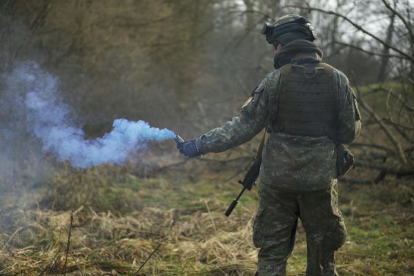 Man in Military Uniform Holding a Signal Smoke