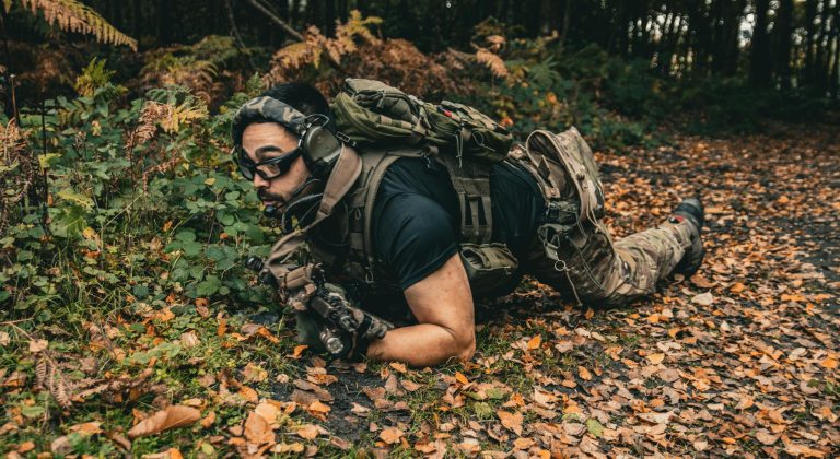 Soldier in Gear and a G36 Assault Rifle Crawling on the Forest Floor